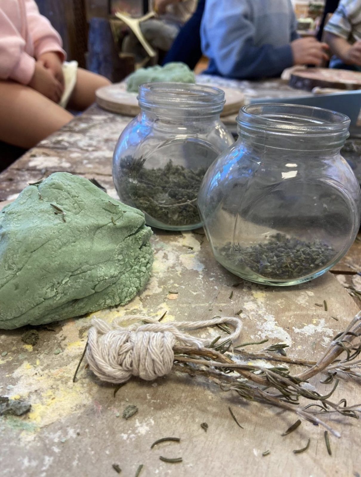 A child grinding herbs with a pestle and mortar at forest school in Newport