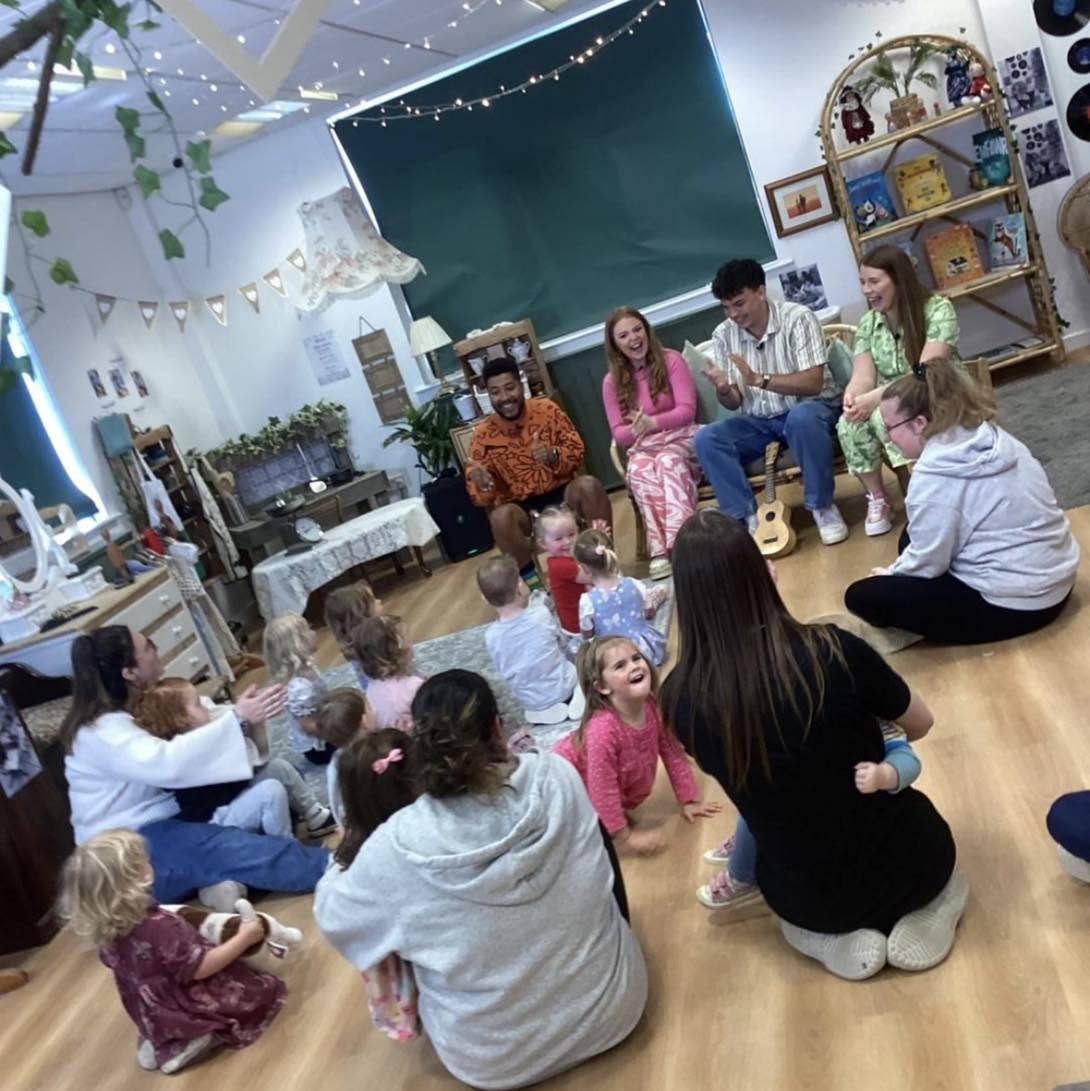 Families and staff singing together in a circle at Wibli Wobli