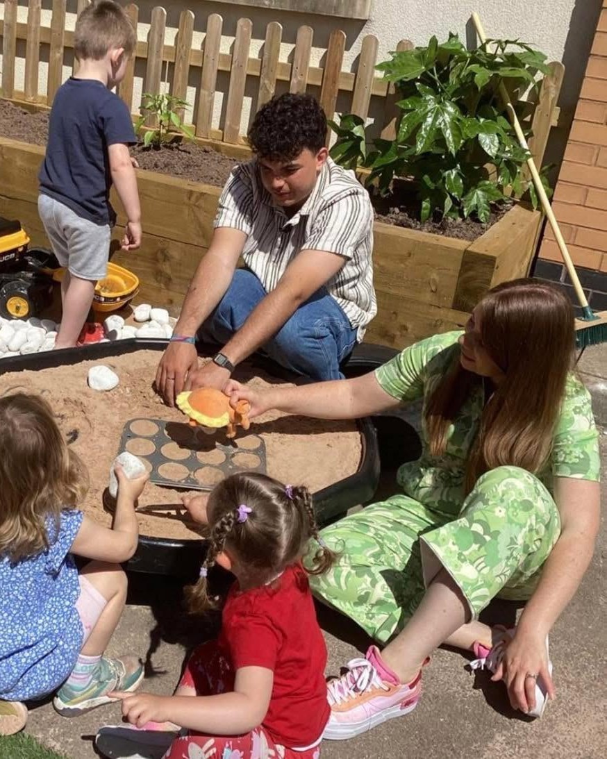 Children and staff exploring sand during the Cyw visit