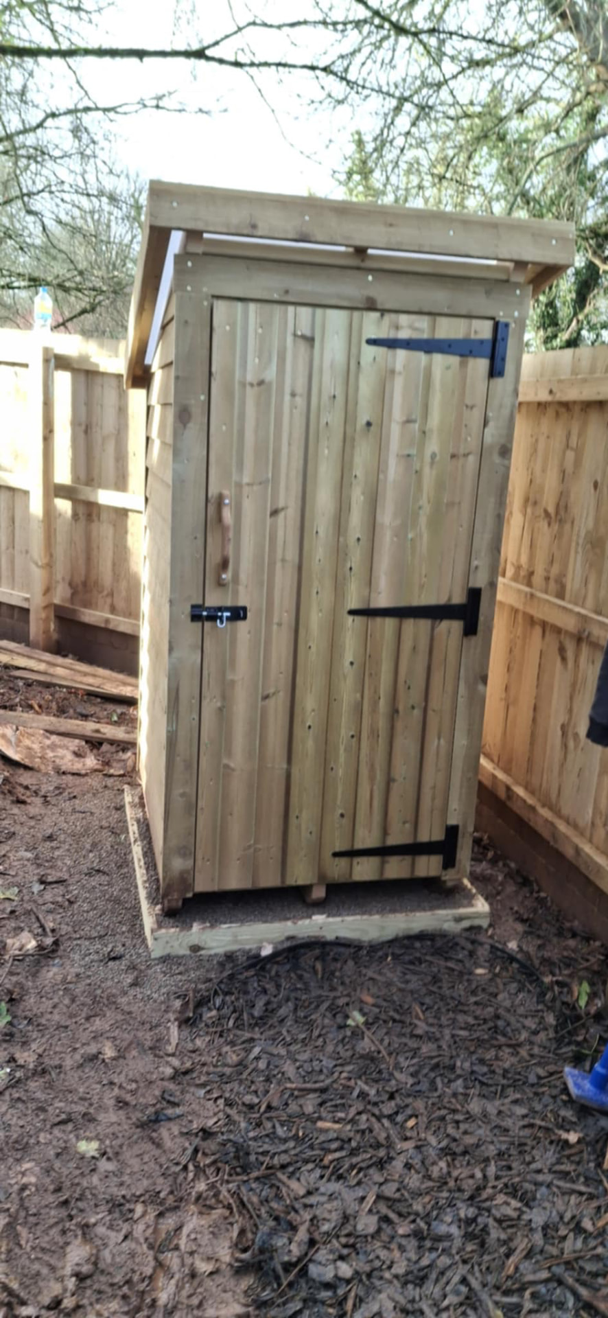 A wooden compost toilet in the forest school outdoor area at Wibli Wobli Newport