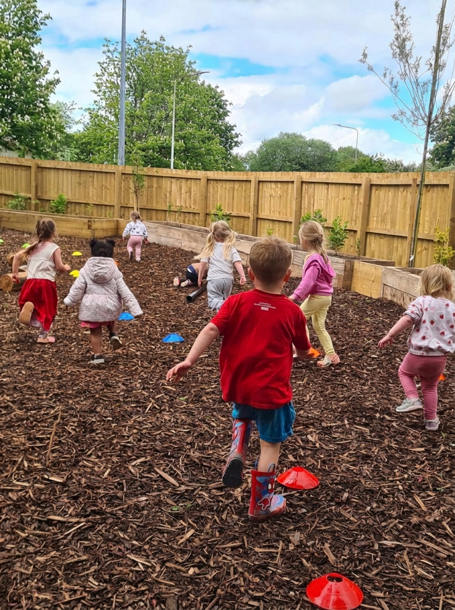 Children running through the woodland forest school area at Wibli Wobli Newport
